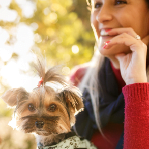 woman and small dog sitting outdoors