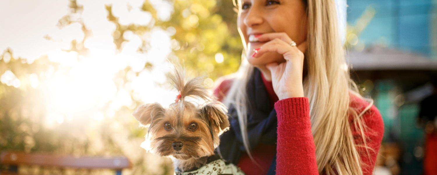 woman and small dog sitting outdoors