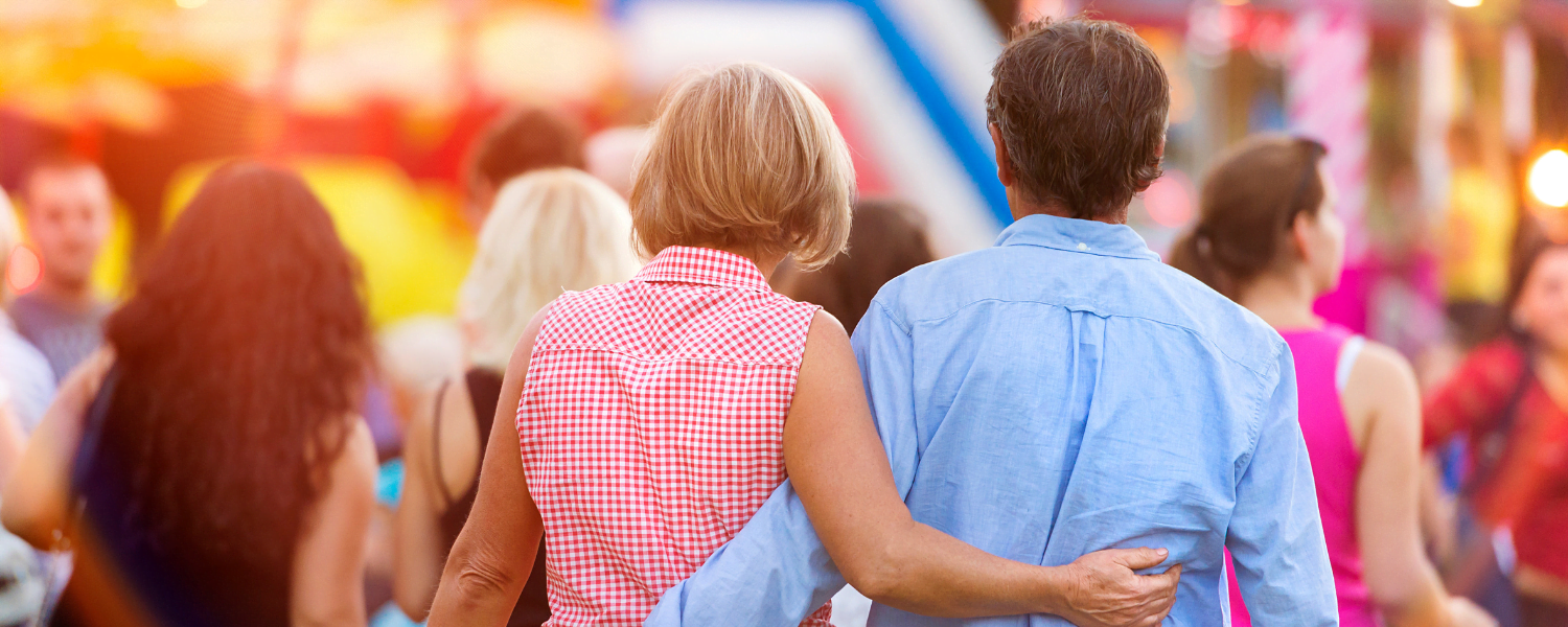 man and woman walking through street festival