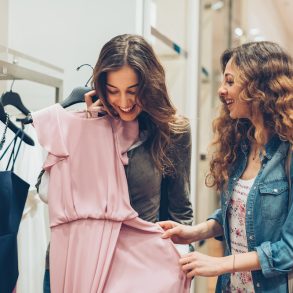 Two young women choosing dresses in a luxury fashion store