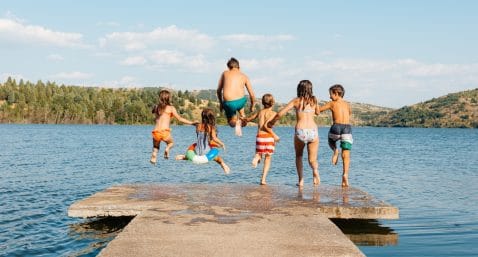 kids jumping in lake off a pier