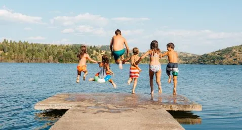 kids jumping in lake off a pier