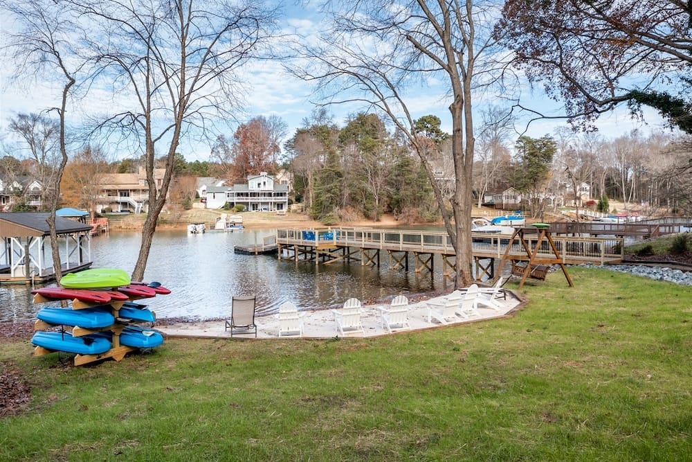 view of kayaks, paddleboards, and chairs at water's edge at Lake Norman