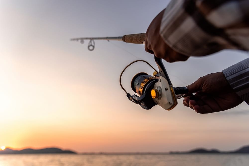 person fishing, close up on the rod and reel