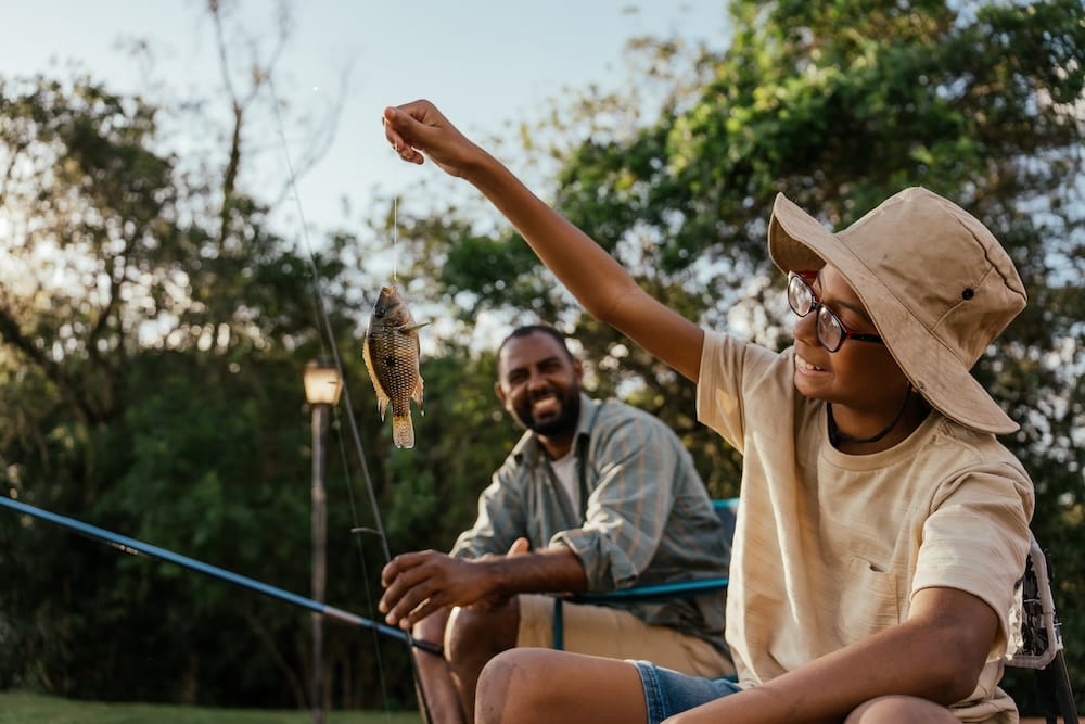 Father and son fishing in the lake relaxing and enjoying nature
